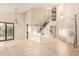 Spacious living room featuring tile floors, high ceilings, and a staircase to the second level at 9812 E Karen Dr, Scottsdale, AZ 85260