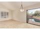 Living room with tile flooring, a modern light fixture, and access to the outdoor pool area at 9812 E Karen Dr, Scottsdale, AZ 85260