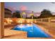 Beautiful backyard pool area with palm trees and outdoor firepit for evening enjoyment at 9812 E Karen Dr, Scottsdale, AZ 85260