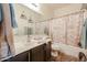 Full bathroom view with a shower-tub combo, wood-look vanity, decor, and beige accents at 10322 W Edgemont Dr, Avondale, AZ 85392
