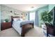 Inviting bedroom with wood-look accent wall, light blue walls, and a decorative piece above the bed at 10322 W Edgemont Dr, Avondale, AZ 85392