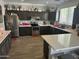 Spacious kitchen featuring stainless steel appliances, dark cabinetry, mosaic backsplash, and a white countertop island at 10322 W Edgemont Dr, Avondale, AZ 85392