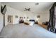 A large main bedroom with light carpet, ceiling fan, white door, and an ensuite bath at 10322 W Edgemont Dr, Avondale, AZ 85392