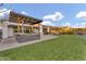 A spacious backyard featuring a built-in grill, covered patio, and lush green lawn at 10719 E Simone Ave, Mesa, AZ 85212