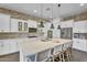 Bright kitchen with white cabinets, stainless steel appliances, large island, and brick accent wall at 10719 E Simone Ave, Mesa, AZ 85212