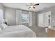 Bright bedroom with a white bed, window with blinds and curtains, and carpeted floors at 10719 E Simone Ave, Mesa, AZ 85212