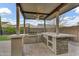 Well-equipped outdoor kitchen with stainless steel grill, ample counter space, and bar seating at 10719 E Simone Ave, Mesa, AZ 85212
