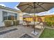 A cozy patio space provides comfortable seating under a large umbrella for shade at 10719 E Simone Ave, Mesa, AZ 85212