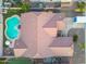 Birds eye view of a home's roof and adjacent outdoor areas that include a green lawn and kidney shaped pool at 10722 E Keats Ave, Mesa, AZ 85209