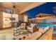 Cozy covered patio with comfortable seating, TV, and views of the pool and backyard at 10722 E Keats Ave, Mesa, AZ 85209