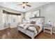 Bright bedroom featuring hard wood floors, light grey walls, ceiling fan, large bed and wall decor at 10722 E Keats Ave, Mesa, AZ 85209
