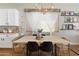 The dining area boasts a wooden table, decorative window coverings, and charming shelving with framed pictures at 10722 E Keats Ave, Mesa, AZ 85209