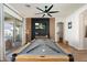 Stylish game room featuring a pool table, modern ceiling fan, black accent wall, and sliding glass doors at 10722 E Keats Ave, Mesa, AZ 85209