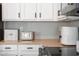 Kitchen close-up with white cabinets, black hardware, tile backsplash, and modern appliances on the counter at 10722 E Keats Ave, Mesa, AZ 85209