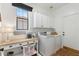 Organized laundry room with washer, dryer, overhead cabinets, and counter space at 10722 E Keats Ave, Mesa, AZ 85209