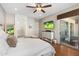 Inviting main bedroom with wood floors, a ceiling fan, and sliding glass doors leading to the patio at 10722 E Keats Ave, Mesa, AZ 85209