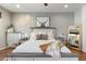 Beautifully decorated main bedroom featuring a patterned accent wall, white bedding, side tables, and a large framed photo at 10722 E Keats Ave, Mesa, AZ 85209