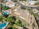 Aerial view showcases a well-maintained backyard with lush grass, mature trees, and a private pool at 11420 N 50Th St, Scottsdale, AZ 85254