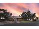 Charming single-story brick home featuring desert landscaping and mature trees against a vibrant sunset sky at 11420 N 50Th St, Scottsdale, AZ 85254