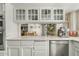 Bright kitchen features white cabinetry, stainless steel appliances, and decorative glass cabinets at 11420 N 50Th St, Scottsdale, AZ 85254