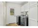 Functional laundry room boasts modern appliances, storage cabinets, and access door to outside at 11420 N 50Th St, Scottsdale, AZ 85254