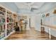 Bright room features built in shelves, ceiling fan, and a workspace with wood floors at 11420 N 50Th St, Scottsdale, AZ 85254