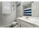 Nautical themed bathroom with white vanity and striped shower curtain at 11554 W Lone Tree Trl, Peoria, AZ 85383