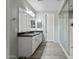 Modern bathroom with double sinks, a large mirror, and a glass-enclosed shower at 11554 W Lone Tree Trl, Peoria, AZ 85383