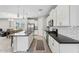 Modern kitchen with white cabinets, stainless steel appliances, dark countertops, and an open layout at 11554 W Lone Tree Trl, Peoria, AZ 85383