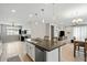 Open kitchen with stainless steel appliances, an island, and views into the dining and living areas at 11554 W Lone Tree Trl, Peoria, AZ 85383