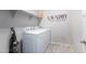 Laundry room with appliances and shelving, plus decorative wall art at 11554 W Lone Tree Trl, Peoria, AZ 85383