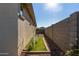 Narrow side yard features artificial turf and secure fencing, perfect for pets at 11554 W Lone Tree Trl, Peoria, AZ 85383