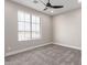 Well lit bedroom with large window, ceiling fan, neutral walls and plush carpet at 13012 S 218Th Ave, Buckeye, AZ 85326