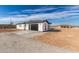 Exterior of a modern stucco home with a dark garage door, tile roof and minimal landscaping at 13012 S 218Th Ave, Buckeye, AZ 85326