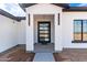 Welcoming entrance featuring a modern glass door, stylish sconces, and a covered porch at 13012 S 218Th Ave, Buckeye, AZ 85326