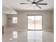 Bright living room with sliding doors, neutral walls, shiny tile floors, and ceiling fan at 13012 S 218Th Ave, Buckeye, AZ 85326