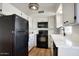 Well-lit kitchen featuring black appliances, white cabinetry, and light countertops at 1320 E Bethany Home Rd # 24, Phoenix, AZ 85014