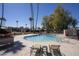 Community pool surrounded by palm trees, lounge chairs, and plenty of space to relax and enjoy the sun at 1320 E Bethany Home Rd # 24, Phoenix, AZ 85014