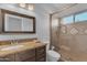 Bathroom featuring vanity with granite countertop, framed mirror, and walk-in shower with glass door at 16002 N 50Th St, Scottsdale, AZ 85254