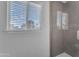 Bright bathroom featuring a window with blinds and a modern tiled shower with glass door at 16002 N 50Th St, Scottsdale, AZ 85254