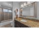 Well-lit bathroom with modern vanity, granite counters, and a shower-tub combo at 16002 N 50Th St, Scottsdale, AZ 85254