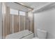 Bright bathroom featuring a tub shower combo, natural wood tile, and toilet at 16002 N 50Th St, Scottsdale, AZ 85254