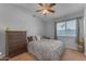 Cozy bedroom with a queen bed, wood dresser, and large window providing natural light at 16002 N 50Th St, Scottsdale, AZ 85254