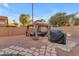Backyard featuring a gazebo with desert landscaping, covered grill, seating area, and privacy fence at 16002 N 50Th St, Scottsdale, AZ 85254