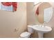 Neutral powder room featuring pedestal sink and an oval mirror at 16528 W Isleta Ct, Surprise, AZ 85387