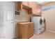 Bright laundry room with front loading washer/dryer and ample cabinet storage space at 16528 W Isleta Ct, Surprise, AZ 85387