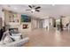 Bright living room featuring tile floors, a stone fireplace, and a mounted television at 16528 W Isleta Ct, Surprise, AZ 85387