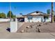Charming single-Gathering home showcasing a white brick exterior with desert landscaping at 1716 W Butler Dr, Phoenix, AZ 85021
