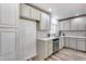 Bright kitchen features stainless steel dishwasher, tile backsplash, and warm wood-look flooring at 1716 W Butler Dr, Phoenix, AZ 85021