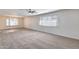 Bright living room with plush carpet, ceiling fan, and natural light from large windows at 1716 W Butler Dr, Phoenix, AZ 85021